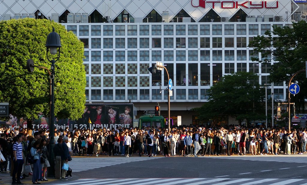 Crowds crossing Shibuya Crossing in Tokyo at dusk