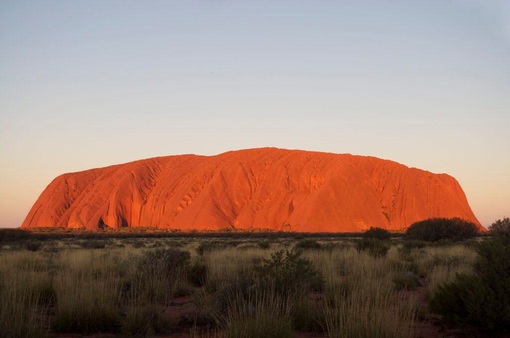 Uluru glowing red at sunset in the Australian desert