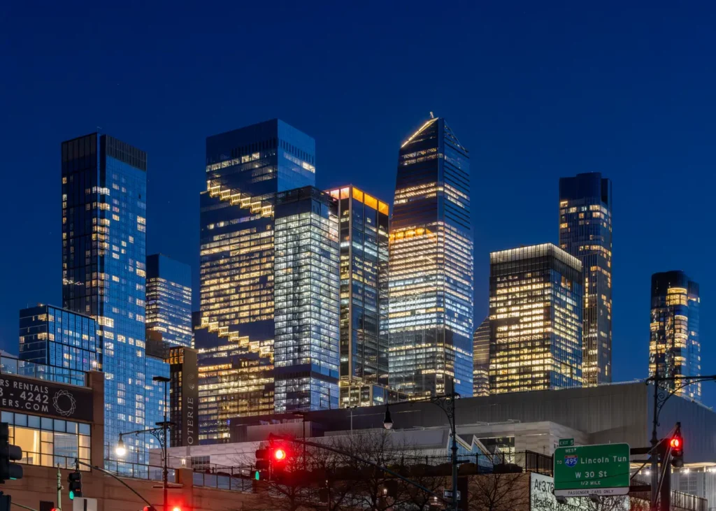 Hudson Yards towers illuminated against the New York City night sky